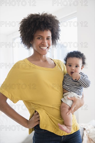 Smiling mother holding baby son