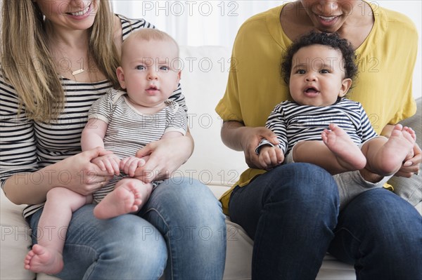 Mothers holding baby sons in laps