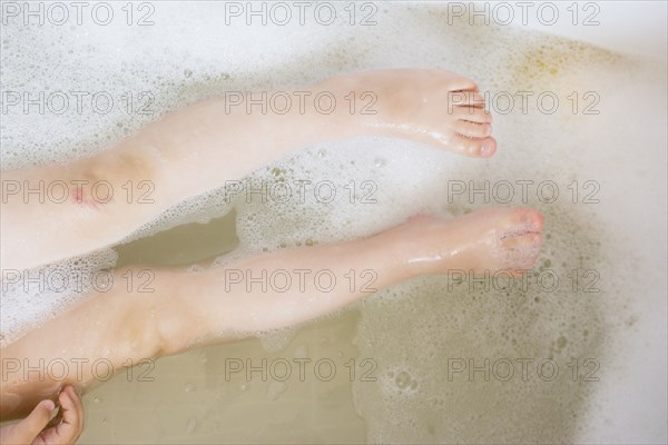 Legs of girl in bubble bath