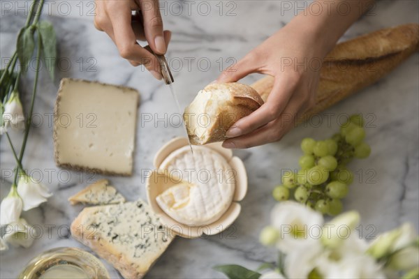 Hispanic woman spreading cheese on bread