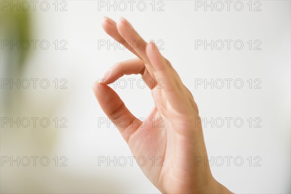 Hand of Hispanic woman gesturing okay