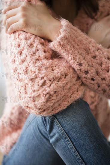 Hispanic woman wearing pink sweater and jeans