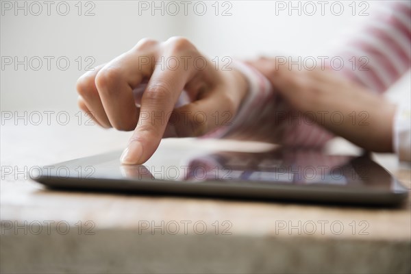 Hands of Hispanic woman using digital tablet