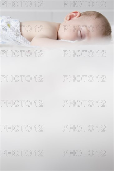 Caucasian baby boy sleeping on bed