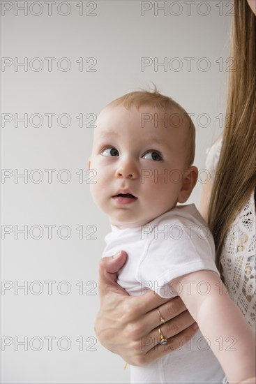Caucasian baby boy looking back at mother