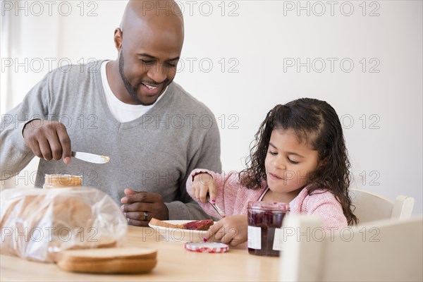 Father and daughter making sandwiches