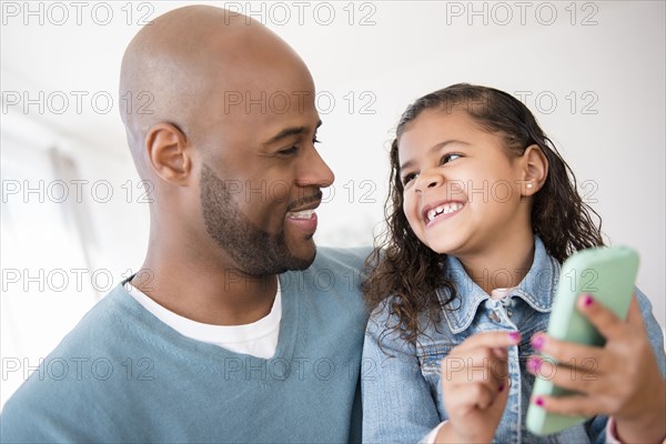 Father and daughter texting on cell phone