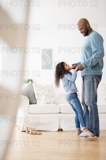 Daughter standing on feet of father and dancing