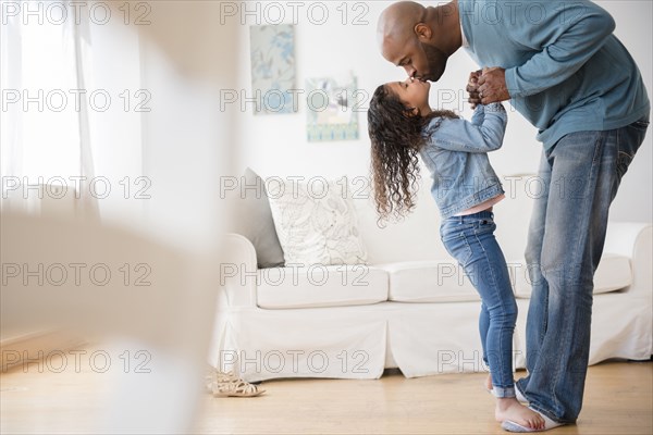 Daughter standing on feet of father and dancing