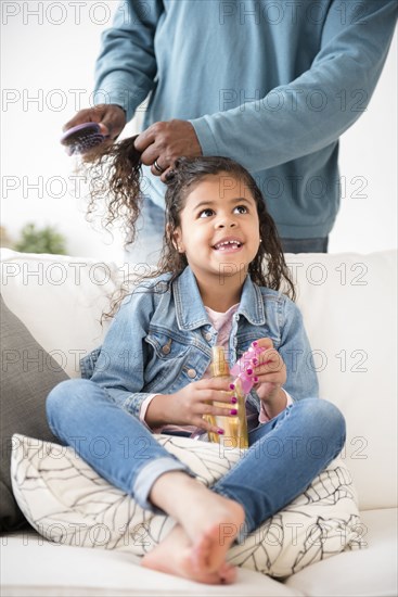 Father brushing hair of daughter