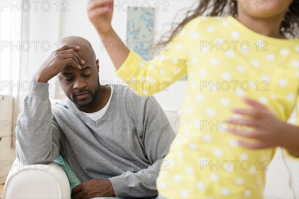 Daughter playing while father has headache