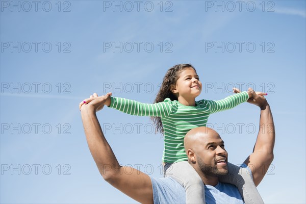 Father carrying daughter on shoulders