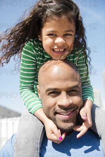 Father carrying daughter on shoulders