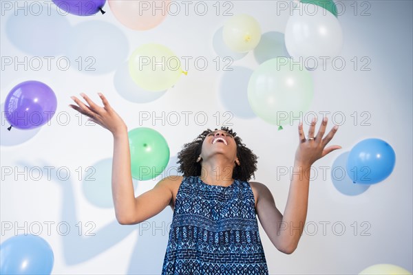 Black woman watching falling balloons