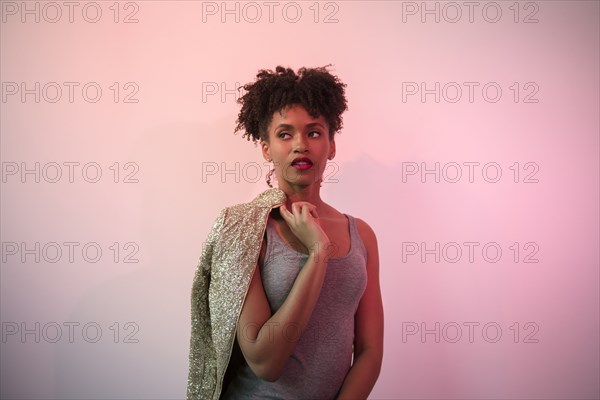 Black woman carrying glamorous jacket on shoulder