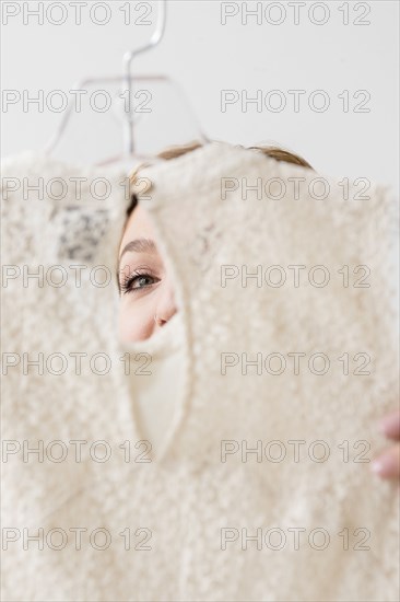 Eye of Caucasian woman examining blouse