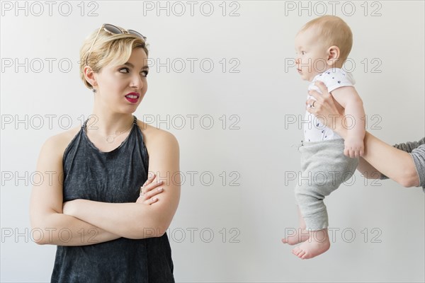 Caucasian woman disgusted at woman offering baby