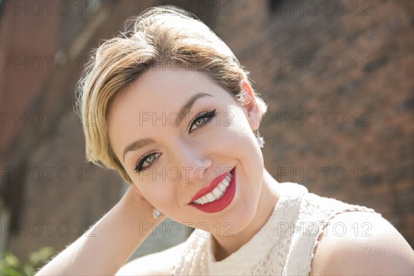 Caucasian woman smiling near brick wall