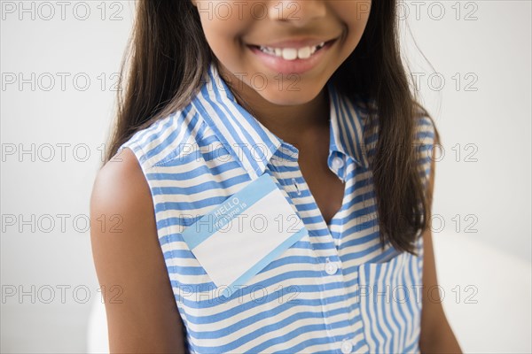 Smiling Mixed Race girl wearing name badge