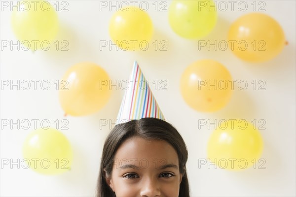 Mixed Race girl wearing party hat