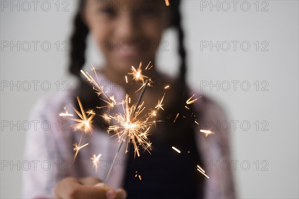 Mixed Race girl holding sparkler