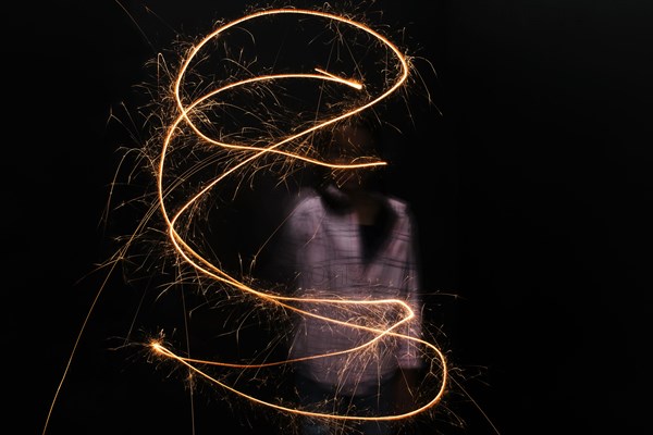 Mixed Race girl twirling sparkler