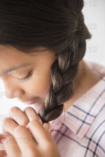 Mixed Race girl braiding hair