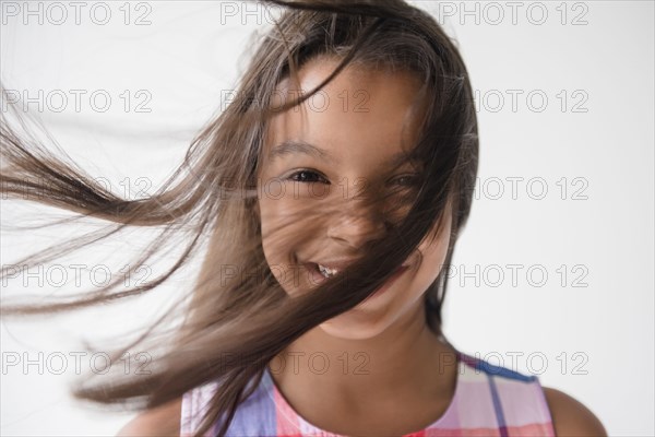 Wind blowing hair of smiling Mixed Race girl