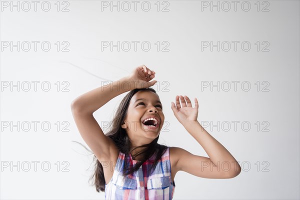 Wind blowing hair of smiling Mixed Race girl