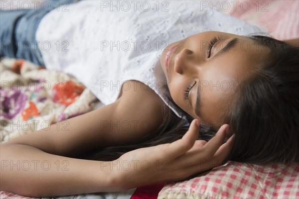Mixed Race girl laying on bed napping
