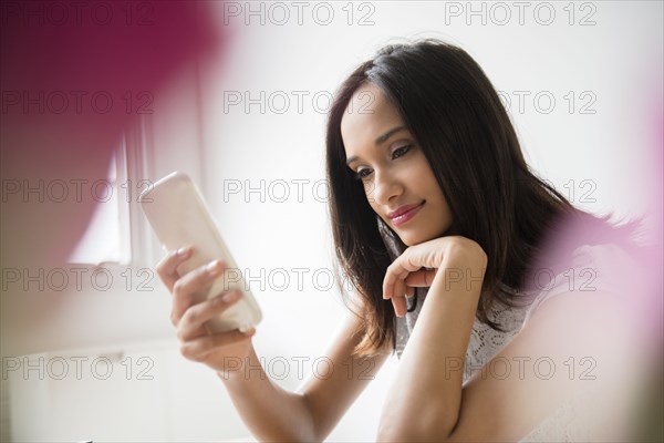 Mixed Race woman texting on cell phone