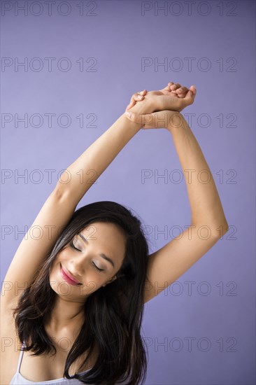 Mixed Race woman stretching arms