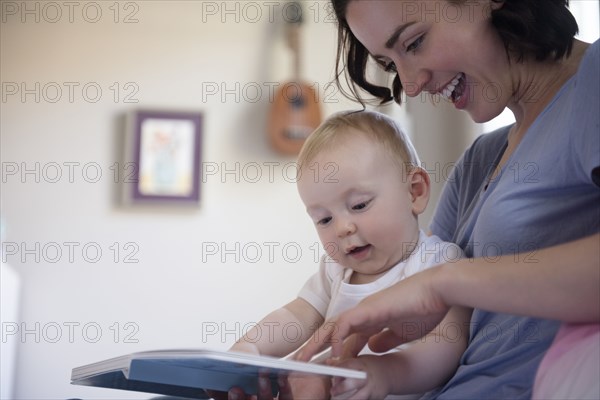 Caucasian mother reading book to baby son