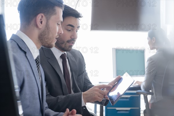 Businessmen using digital tablet in office