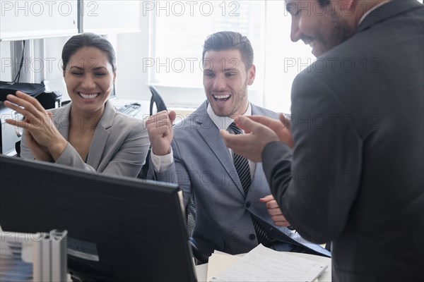 Smiling business people celebrating in office