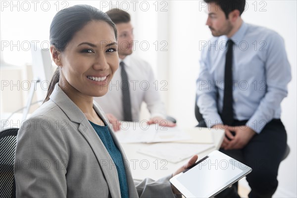 Smiling businesswoman holding digital tablet in office