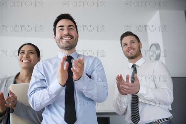 Business people applauding in office meeting