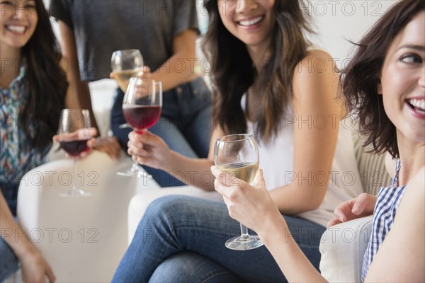 Smiling women drinking wine at party