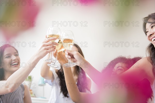 Smiling women toasting with white wine