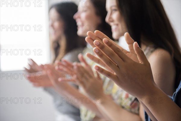 Smiling women applauding