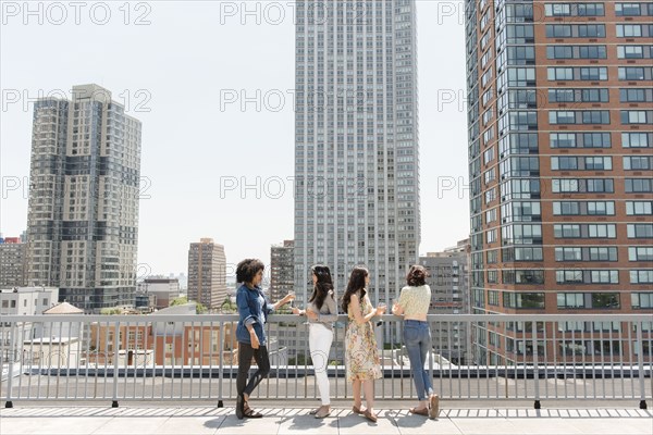 Women drinking wine on urban rooftop