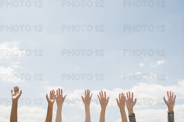 Raised hands of women outdoors