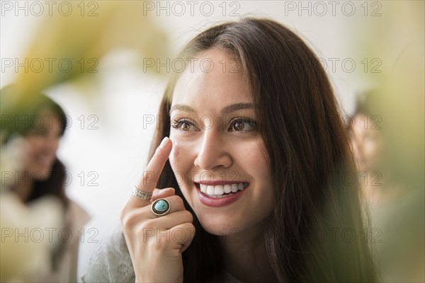 Smiling woman applying moisturizer to face