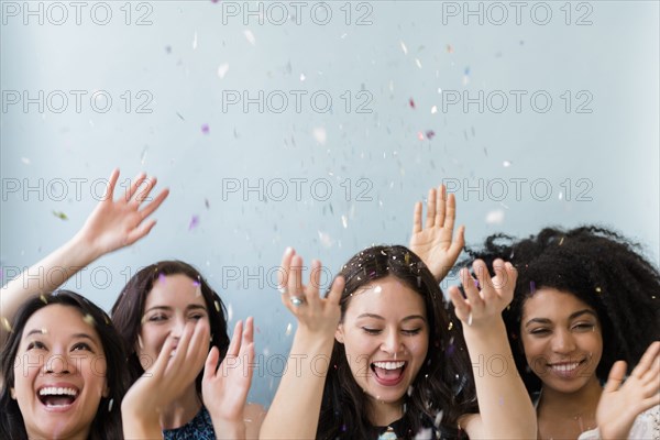 Smiling women throwing confetti