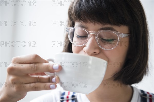 Hispanic woman drinking coffee