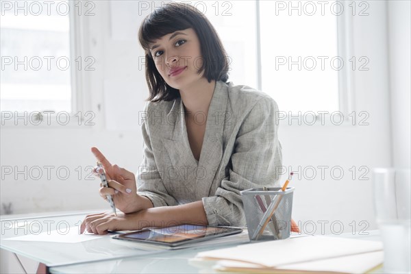 Hispanic businesswoman in office with digital tablet