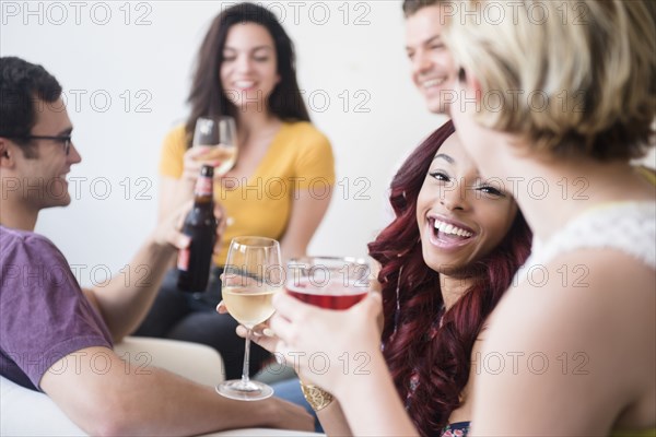 Smiling friends drinking at party