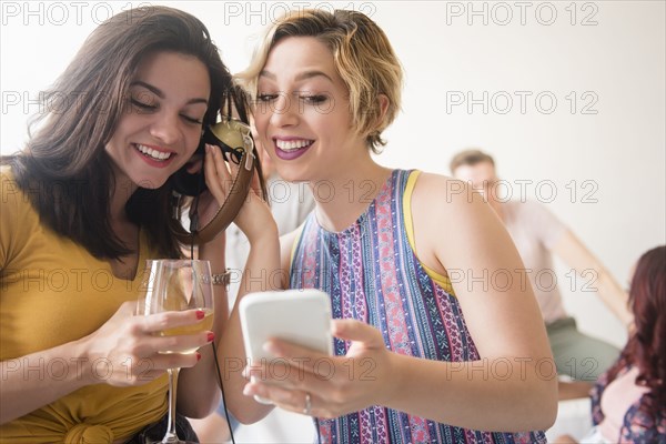 Women listening to cell phone with headphones