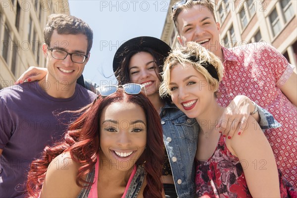 Portrait of smiling friends posing in city