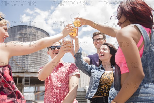 Smiling friends toasting with beer outdoors
